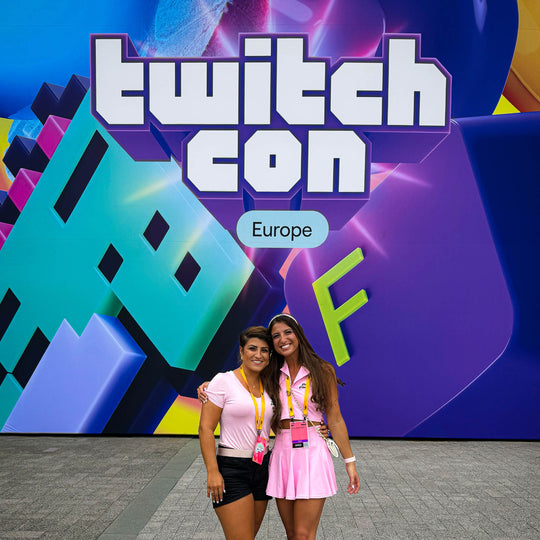 G and a friend in pink in front of the TwitchCon Europe sign