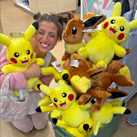 G laughing in a pile of Pikachu and Eevee plushes